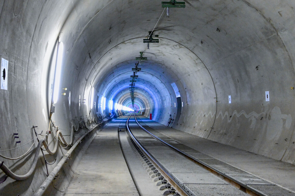 Tracks accessible for traffic vehicles in a clean, new tunnel, with white and blue lightning.