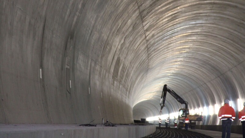 Construction site in a spacious tunnel with bright, artificial light.